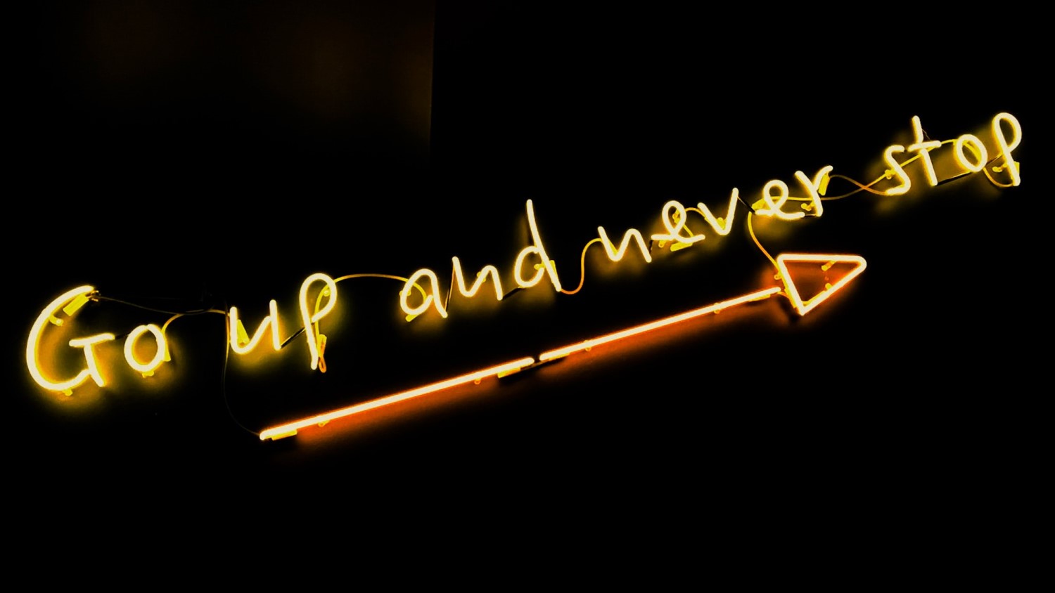 neon sign 'go up and never stop'